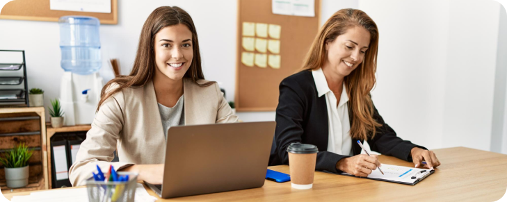 two female coworkers smiling in office