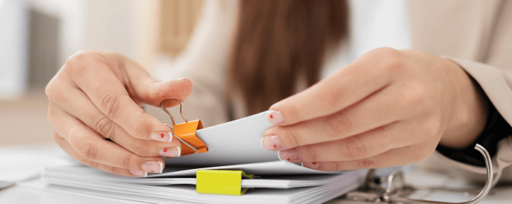 person organizing reports with clips