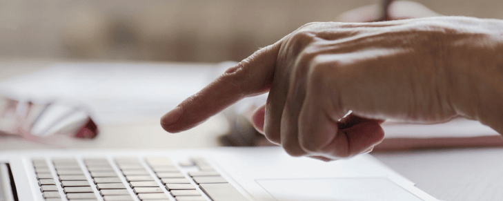 finger pointing at laptop keyboard