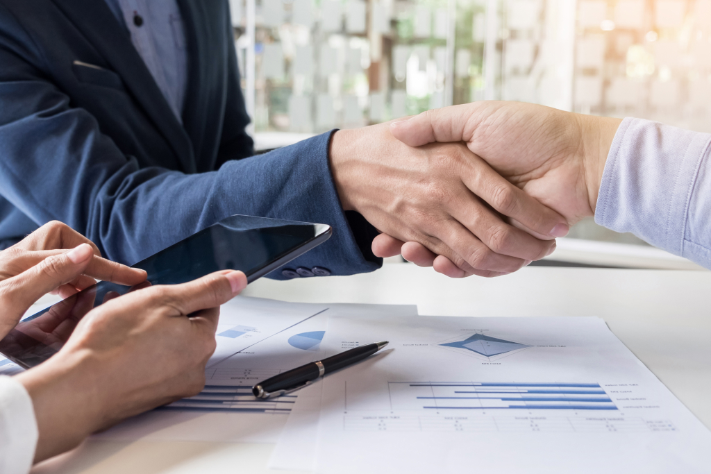 two individuals shaking hands in agreement