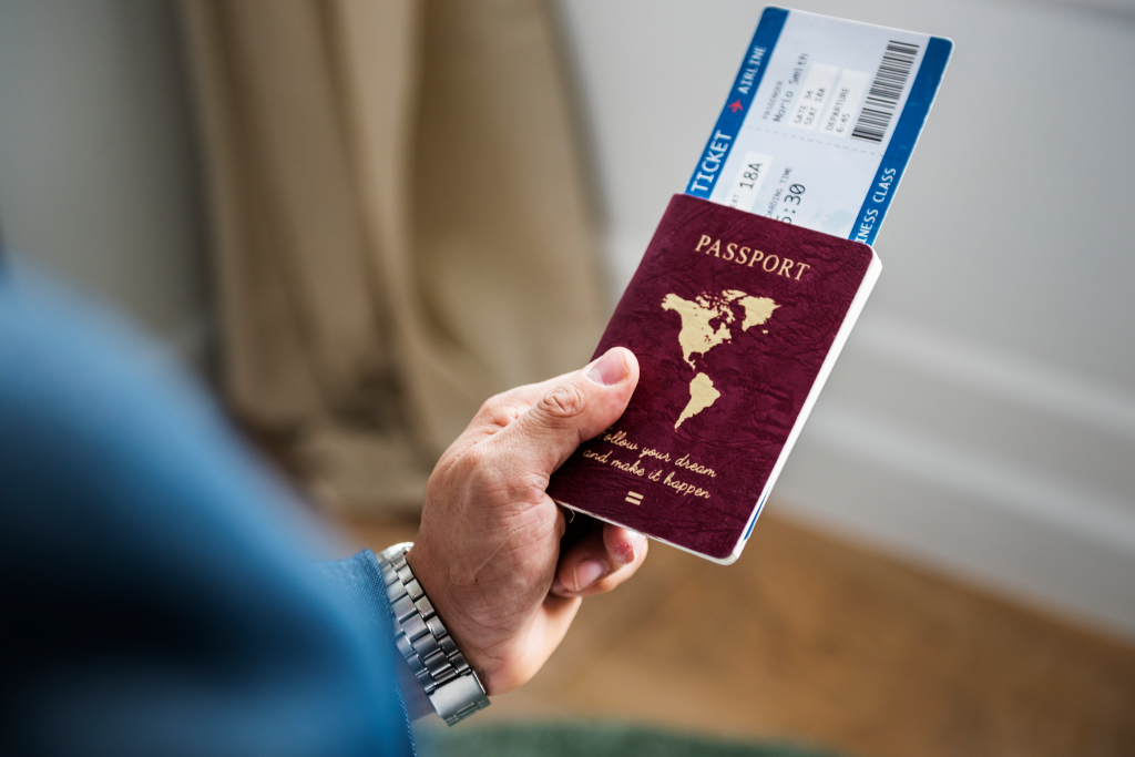 man holding passport and travel tickets