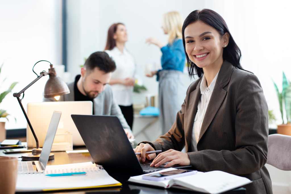 woman smiling with team working behind