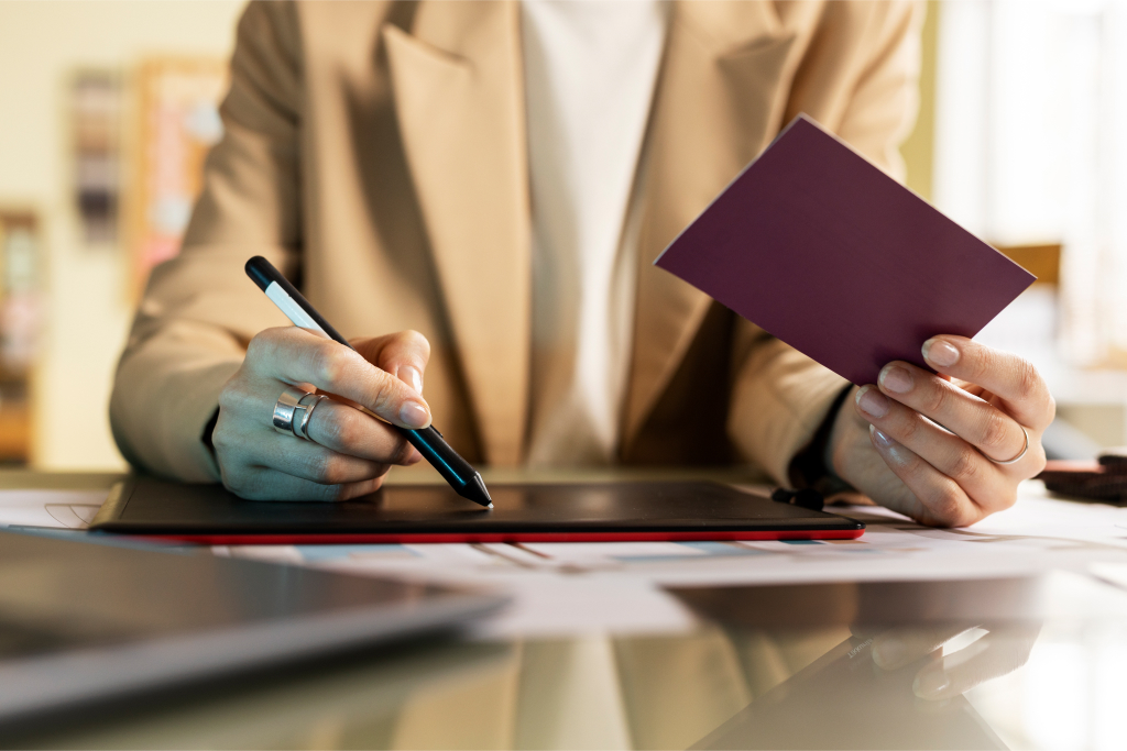 man writing on drawing pad holding card