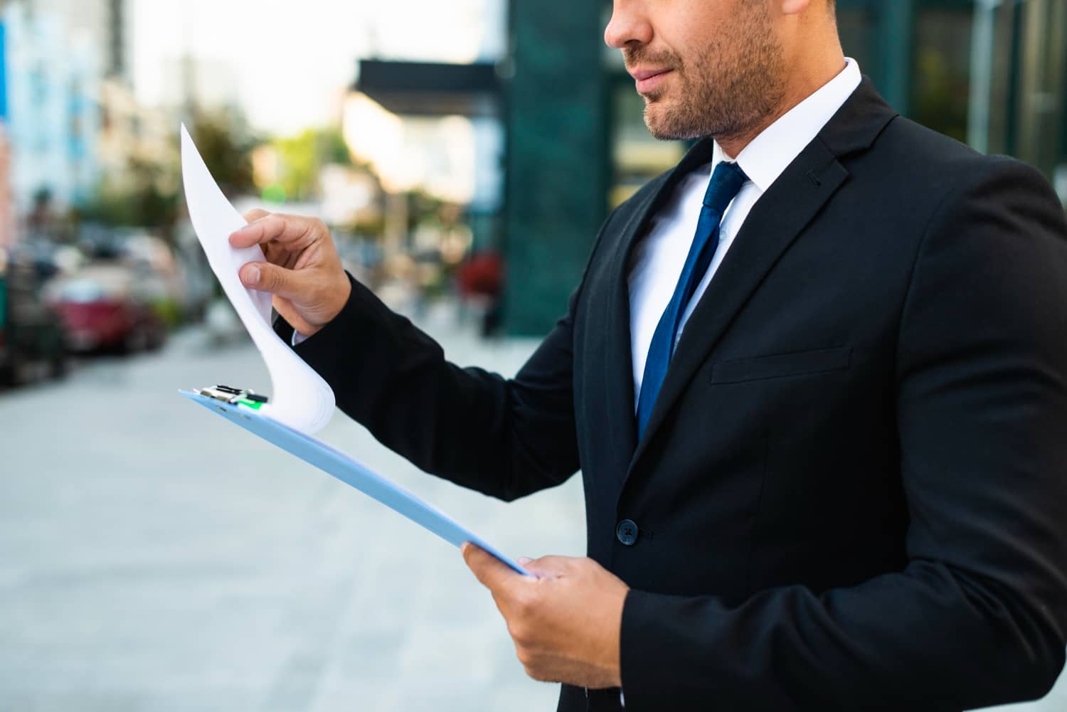 man reviewing document on clipboard