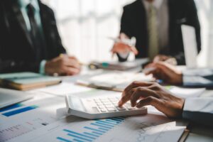 Business team calculating corporate tax obligations before Singapore IRAS filing deadlines